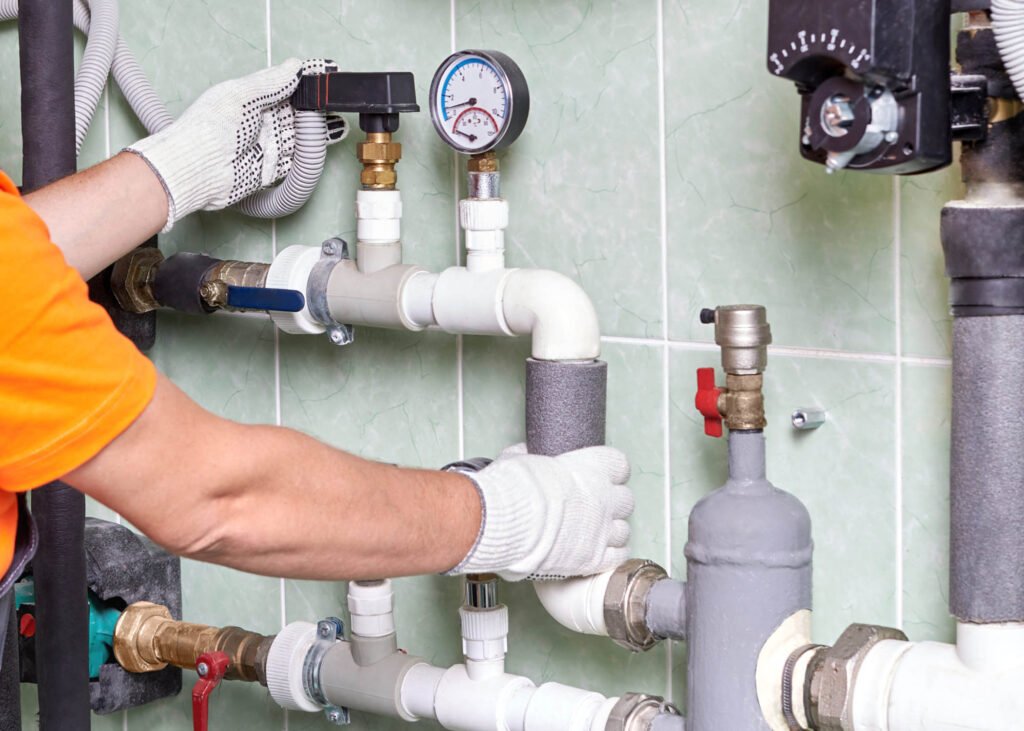 A worker or an engineer checks the operation of the heating system in a room with engineering communications in an apartment building.